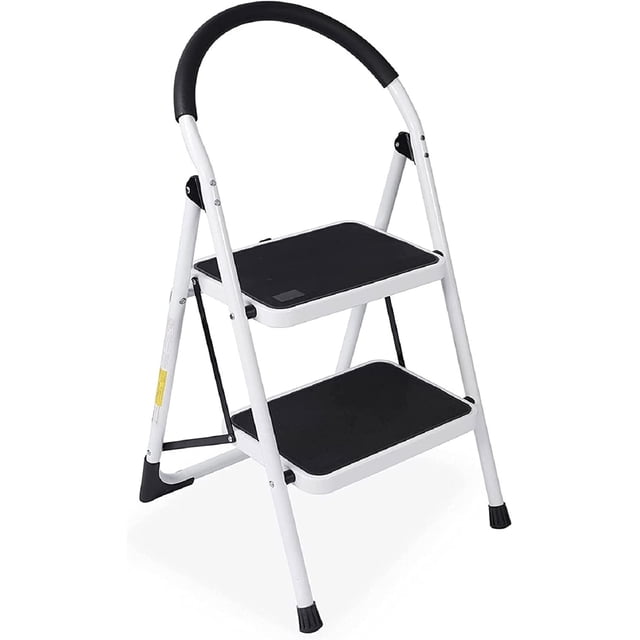 WAYPLUS 2 Step Steel Ladder, a folding portable step stool with non-slip feet and rubber pads, designed for a 330lb capacity. The ladder features a white steel frame with black anti-slip textured steps and a sponge-covered handgrip for added comfort and stability. It includes rubber feet to prevent slipping and floor scratches. The compact, foldable design allows for easy storage in tight spaces like garages or under beds. Suitable for use in kitchens, offices, gardens, and more.