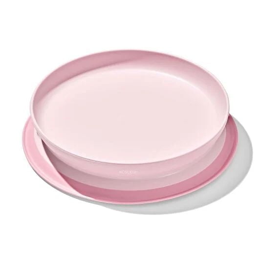 Oxo Tot Stick & Stay Suction Plate in blossom pink for toddlers 6 months and older, featuring a secure suction base to prevent slipping and tipping, raised side walls to aid self-feeding, parent-friendly design for easy removal, dishwasher safe and twists apart for cleaning.