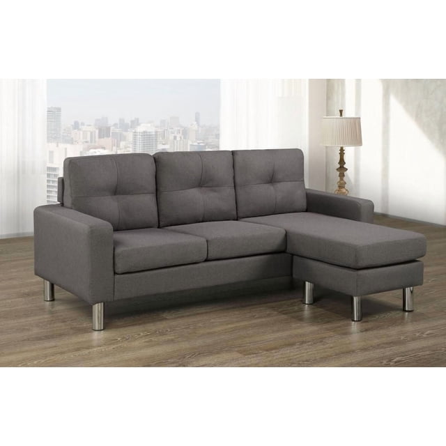 Sandra Sectional, Dark Grey, a modern L-shaped sectional sofa with a reversible chaise on the right side, upholstered in durable 100% polyester fabric with tufted back cushions and chrome finished legs, set on a wood floor in a bright room with sheer curtains and city skyline view, ideal for versatile living room seating.
