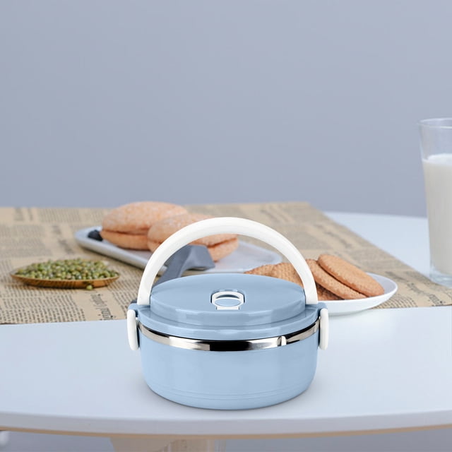 RKSTN Lunch Box Stainless Steel Lunch Box Fresh-Keeping Box Multi-Layer Plastic Student Insulation Lunch Box in a light blue color with a white ergonomic bow handle. The lunch box features a vented lid for airtight sealing, stainless steel interior for durability, and side locks for a secure fit. It is displayed on a table with cookies, green lentils, and a glass of milk in the background.