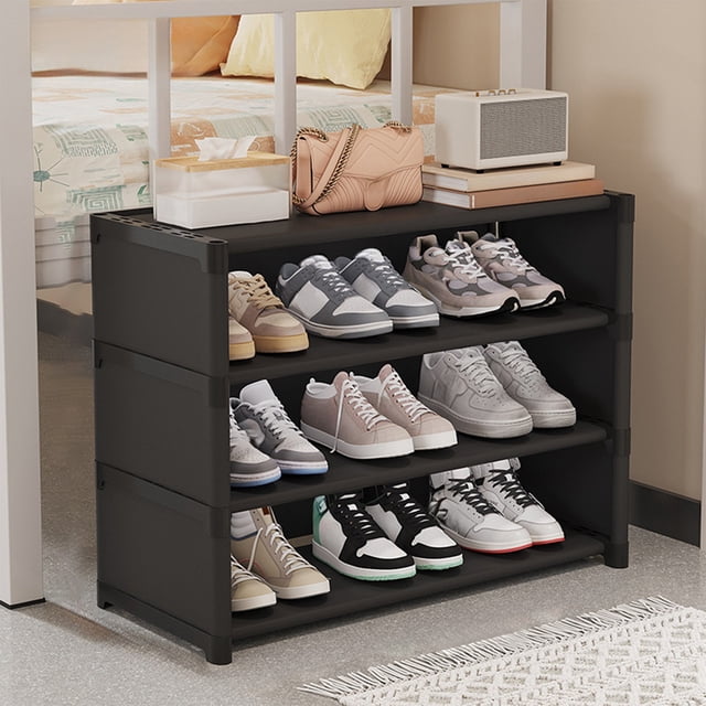 Amzcrzy Pla Stic Shoe Cabinet Shoe Rack Simples Multi Layer Dusts Proof Shoe Cabinet designed for dorm room essentials and entryway organization. The black plastic shoe rack features four tiers, providing ample storage for various shoes. Compact and space-saving, it fits neatly under tables or in small corners. The sturdy structure ensures durability and stability, while the open design allows for easy access and ventilation. Shown in a bedroom setting with shoes neatly arranged on the shelves and additional items like a bag and books placed on top.