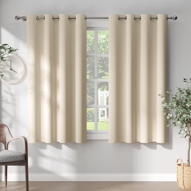 Curtainking Rideaux Occultants Lot de 2 Rideaux à Oeillets Assombrissants pour Salon, 50x63 Pouces, Beige. l'Image Montre Deux Rideaux Occultants Unis Beige avec un design à Oeillets, Suspendus sur une Tringle à Rideaux Argentée devant une Fenêtre. les Rideaux Sont Faits d'Un Tissu à triple Tissage, Conçus pour Bloquer 80 % de la Lumière du Soleil et des Rayons UV, Assurant l'Intimité et un Environnement Intérieur Plus Silencieux. le Cadre Comprend un Salon Moderne avec une Chaise, une Plante en Pot et un Filtre de Lumière Naturelle à Travers la Fenêtre