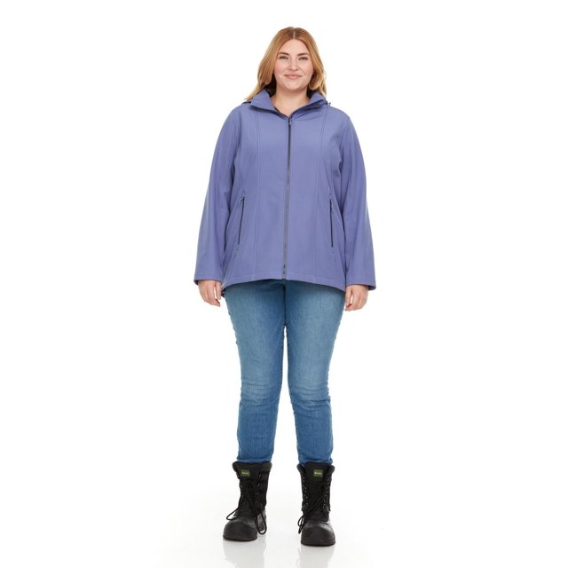 Swiss Tech Veste Coquille Souple à Capuche pour Femme Grande Taille en Bleu, Montrée à l'Avant sur un Modèle Portant un Jean Bleu Pâle et des Bottes à Lacets Noires, avec Tissu Coquille Souple Résistant à l'Eau, Fermeture Éclair Complète à l'Avant, Poches à Main Zippées et une Capuche Détachable et Ajustable.