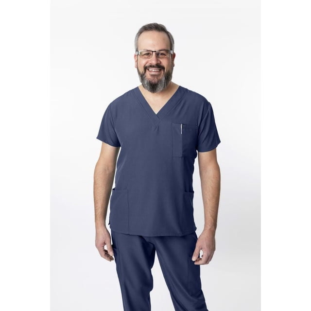 Greentown Canada Scrubs 4Flex 1202 Unisex Scrub Top in navy blue on a front-facing model wearing matching scrub pants. The athletic fit V-neck top has short sleeves, three pockets including a chest pocket with pen slot, made from a 93% polyester and 7% spandex blend with 4-way stretch and moisture-wicking fabric for comfort and mobility.