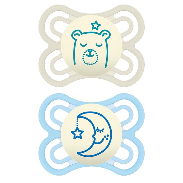MAM Perfect Night Pacifiers 2 pack for 0-6 months baby boys, glow in the dark with one beige pacifier showing a teal sleeping bear and star, and one light blue pacifier featuring a blue crescent moon with a hanging star, both with ventilated butterfly-shaped shields designed to reduce jaw pressure and support breastfeeding.