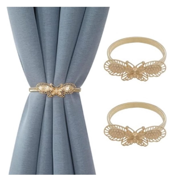 IH Casa Decor Set Of 2 Curtain Tiebacks Butterfly Rose Gold featuring two rose gold metallic butterfly-shaped tiebacks with fern patterns, one shown holding a blue curtain, ideal for window coverings and drapery hardware.