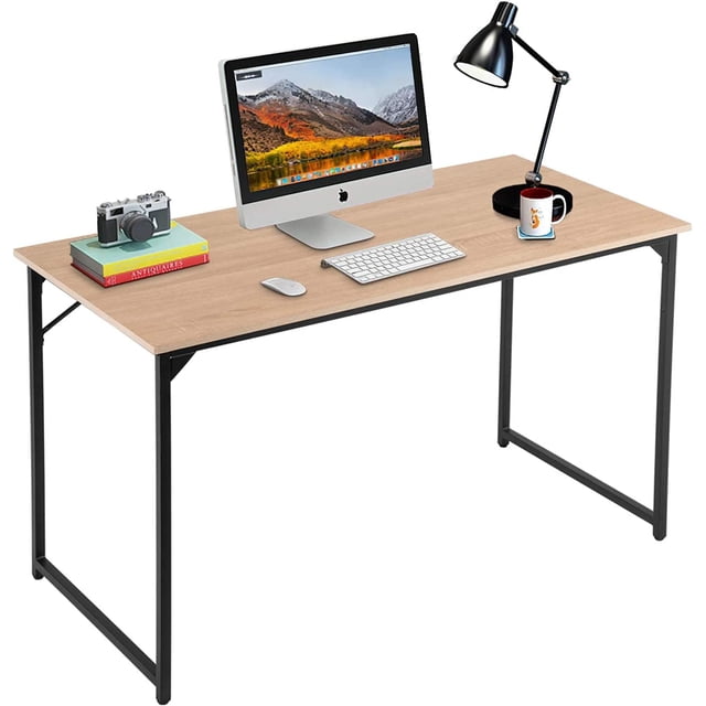 BestOffice Computer Desk, Home Writing Study Table Modern Simple Style PC, Metal Frame for Home Office. The desk features a spacious rectangular wooden desktop with a natural finish, supported by a sturdy black powder-coated metal frame with track-leg construction. It includes adjustable leg pads for stability on uneven floors and a scratch-resistant, waterproof surface. The desk is shown in a home office setting with a computer, desk lamp, books, and a coffee mug placed on top.