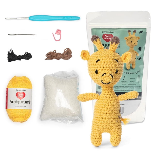 Red Heart™ AMIGURUMI Crochet Trousse de Collection au avec une Girafe Jaune au Crochet Complète avec des Taches Brunes, Affichée à Côté du Contenu de la Trousse Incluant du Fil Jaune, du Fil Noir et Brun, du Rembourrage en polyester, un Crochet Bleu, une Aiguille à Fil, un Marqueur de Point et une Feuille de Motif dans un Sac Refermable.