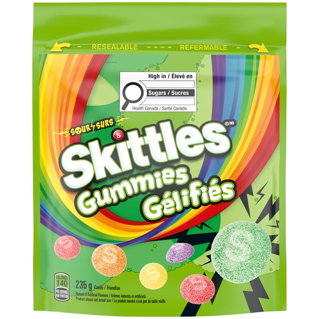 SKITTLES Sour Gummies Chewy Candy 235g resealable bag with multicoloured sour gummy candies in strawberry, orange, lemon, grape, and green apple flavours on a green background with rainbow accents and a Health Canada sugar warning label.