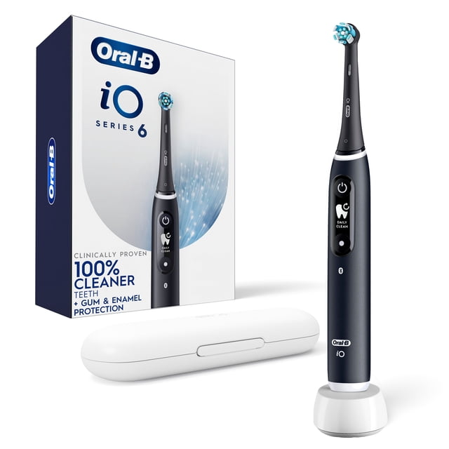 Oral-B iO Series 6 Electric Toothbrush with (1) Brush Head, Black Lava shown upright on a white charging stand with a white travel case nearby and the product box in the background displaying the Oral-B logo and claims of 100% cleaner teeth with gum and enamel protection, featuring a black handle with an interactive display and round brush head design.