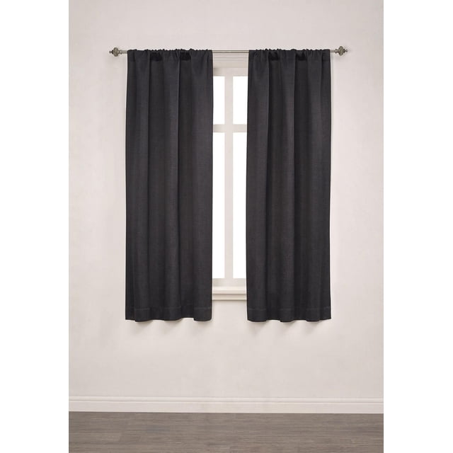 Mainstays Chambray Blackout 63" Window Curtains Panel Pair in black heather texture, hanging on a metal rod over a window with white trim, made of 100% polyester microfiber with triple foam backing for 100% blackout, each panel 40 inches wide and 63 inches long, suitable for bedroom window treatments to block light and enhance privacy.