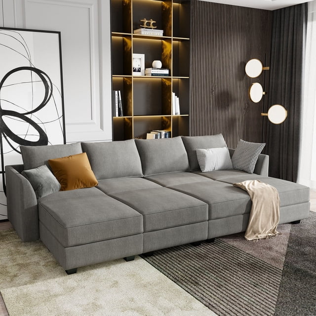 HONBAY Convertible Modular Sectional Sofa Bed in grey, showcased in a modern living room. The sofa is arranged in a U-shape with breathable linen fabric and high-density foam cushions for comfort. It offers versatile configurations, including L-shape and sofa bed layouts, and features storage space under each seat. Built with thickened plastic legs and a solid wooden frame for durability, it is ideal for living room seating or sectional sofa needs. Decorative pillows and a throw blanket complete the cozy look.