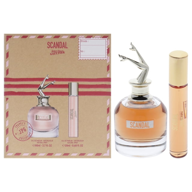 Jean Paul Gaultier Scandal 2 Pc Gift Set featuring a 2.7oz EDP spray and a 0.68oz EDP spray. The set includes a woody spices fragrance with notes of honey, patchouli, gardenia, mandarin orange, blood orange, jasmine, peach, and licorice. The packaging showcases the iconic bottle design with a metallic cap shaped like legs and a travel-size spray. Ideal for gifting or personal use.