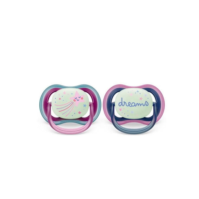 Philips Avent Ultra Air Pacifier 6-18m, falling star / dreams, nighttime, 2 pack SCF376/14 with two pacifiers featuring lightweight, breathable shields; one has a pink and blue frame with a glowing star and shooting star design, the other a pink and navy frame with the word 'dreams' and small stars, both with soft silicone nipples for sensitive baby skin and easy nighttime use.