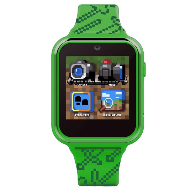 Minecraft Montre Interactive à Écran Tactile avec Caméra dans un Boîtier en Plastique Vert et un Bracelet Mettant en Vedette des Épées et des Pioches Minecraft Pixélisées, Affichant un Écran Tactile avec des Icônes pour les Fonctions Caméra, Enregistreur Vidéo, Podomètre et Visionneuse d'Albums.