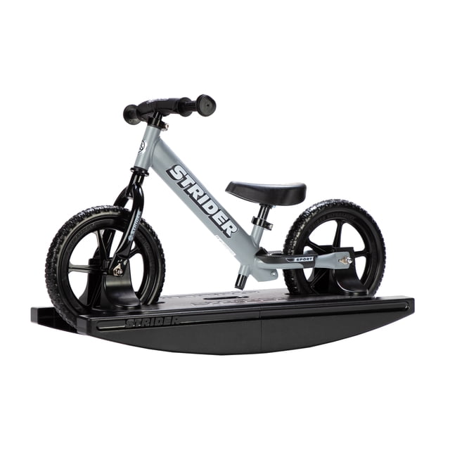 Strider - 12 Sport 2-in-1 Rocking Bike in matte gray, designed for children aged 6 months to 5 years. The bike is securely mounted on a black rocking base, allowing babies to develop balance and coordination. Features include a lightweight frame, no-tool adjustable seat and handlebars, padded seat, and never-flat tires. The rocking base can be detached, transforming it into a balance bike suitable for toddlers with an inseam of 22-51 cm (8.75-20 in.).