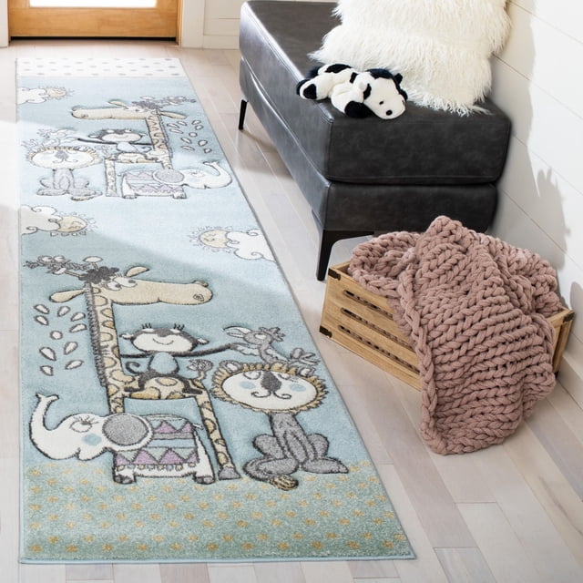Safavieh Carousel Kids Talisha Sunshine Animals Area Rug with pastel blue background and storybook animal outlines including giraffe, lion, elephant, and monkey, power-loomed synthetic yarn for durability, displayed on light hardwood floor beside a dark gray bench with a plush panda and a wooden crate holding a chunky knit pink blanket, suitable for kids' room decor.