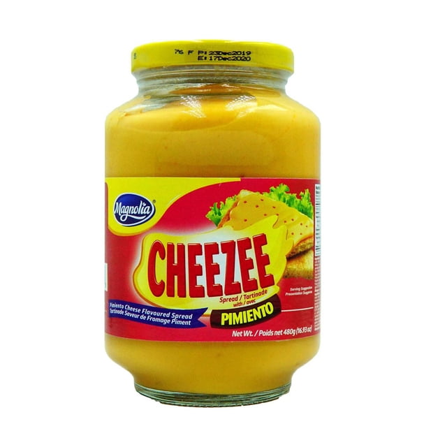 Magnolia Tartinade de Pimiento Cheezee dans un Pot en Verre Transparent Refermable avec Couvercle Jaune, Présentant une Étiquette Rouge et Jaune avec le logo Magnolia et le Nom du Produit, Contenant 480 g de condiment Crémeux à Saveur de Pimiento, Tartinable, Convenant aux sandwiches et à la Cuisine.