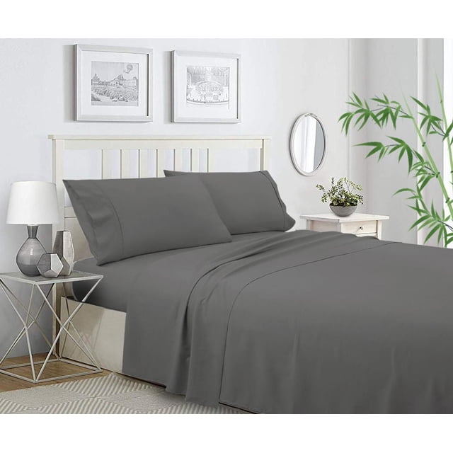 Ensemble de Draps en Mélange de Bambou en Gris Foncé Uni sur un Cadre de Lit à Lattes Blanc, Incluant Drap Plat, Drap-Housse et Deux Taies d'Oreiller Faits de 65 % de Polyester et 35 % de Rayonne de Bambou pour la Respirabilité et la protection Antibactérienne. la Chambre Présente une table d'Appoint Géométrique en Métal avec une Lampe Blanche, une table de Nuit Blanche avec une Petite Plante, Deux Imprimés Encadrés Noir et Blanc, un Miroir Mural Ovale et une Plante de Bambou Près de la Fenêtre, Mettant l'Accent sur un Ensemble de Draps Durable et Évacuant l'Humidité