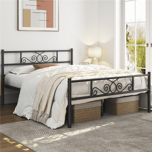 Yaheetech Graceful Scroll Metal Platform Bed with Headboard and Footboard, Queen, Black. This bed features a powder-coated metal frame with decorative scroll designs on the headboard and footboard. The black iron frame is scratch and oxidation-resistant, offering an 800 lb weight capacity. The platform design includes 12.6 inches of under-bed storage space, ideal for organizing storage boxes or other items. Shown in a bright bedroom setting with natural light, a beige rug, and wicker storage baskets under the bed.