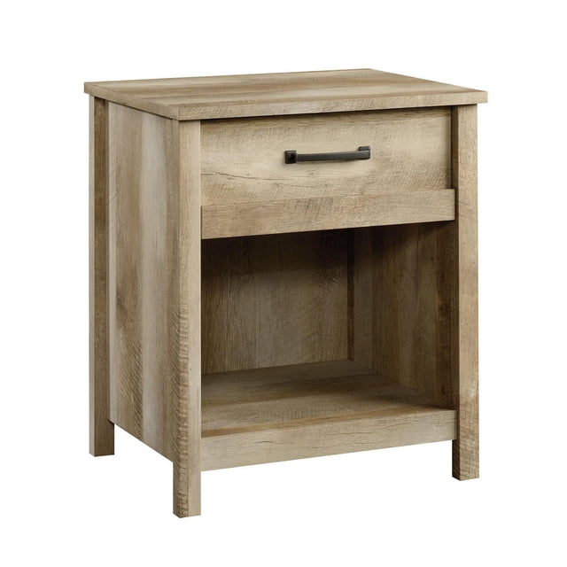 Sauder® Cannery Bridge Night Stand in natural wood finish with a single drawer on metal runners and safety stops, black metal handle, and an open shelf for additional storage, shown in a front 3/4 view suitable for bedroom furniture and ideal for organizing bedside essentials.