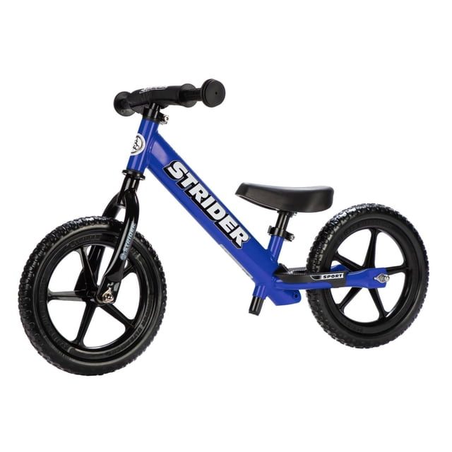 Strider 12 Sport Balance Bike in blue, designed for children aged 18 months to 5 years. Features a lightweight steel frame, flat-free foam rubber tires, and an ergonomically padded seat. Includes mini-grips for small hands, an extra-long seatpost for growth, and a built-in footrest for balance practice. The bike has ultralight molded wheels with maintenance-free sealed cartridge bearings and an easy-adjust clamp system for seat and handlebar adjustments.