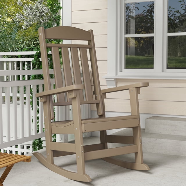 FOOWIN Patio Slat Rocking Chair in brown, made of HDPE plastic for weather resistance and durability. This oversized porch rocker features an ergonomic backrest, smooth rocking motion, and a sturdy structure with a 350-pound weight capacity. The chair measures 26.7 inches wide, 35.4 inches deep, and 44.5 inches high, with a slatted design for easy rainwater drainage. Shown on a porch with a beige siding background and greenery.