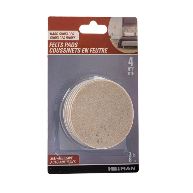FELT PADS 3" OATMEAL 4PC containing four round, oatmeal-coloured self-adhesive felt pads designed to protect hard floors and furniture legs from scratches and dents on wood, tile, linoleum, and laminate surfaces, packaged on a grey and rust Hillman card with a bedroom image, also suitable for reducing noise when moving furniture.