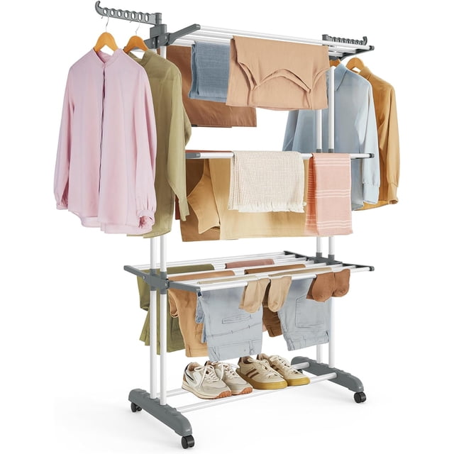 SONGMICS Clothes Drying Rack Stand 4-Tier in white, made of steel and plastic, with three top tiers, two rotating wings with 14 slots, and a bottom tier for shoes. The rack is shown holding various clothes, towels, and shoes, demonstrating its large capacity. It features four casters, two with brakes for stability, and is suitable for indoor or outdoor use. Dimensions are 25.2 inches deep, 49.6 inches wide, and 67.7 inches high when unfolded.