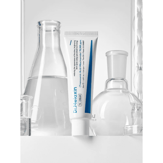Dr.Melaxin TX Cream 50ml tube positioned upright among clear laboratory glassware including a conical flask, round-bottom flask, and beaker, highlighting this lightweight face moisturizer formulated with tranexamic acid and niacinamide to enhance skin radiance, even complexion, and hydration.