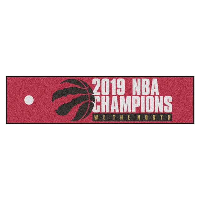 Fanmats NBA Champion Toronto Raptors Putting Green Mat with a red nylon surface featuring the black claw basketball logo, white '2019 NBA Champions' text, and a black and gold 'We The North' backstop, designed for realistic golf putting and stable placement on floors.