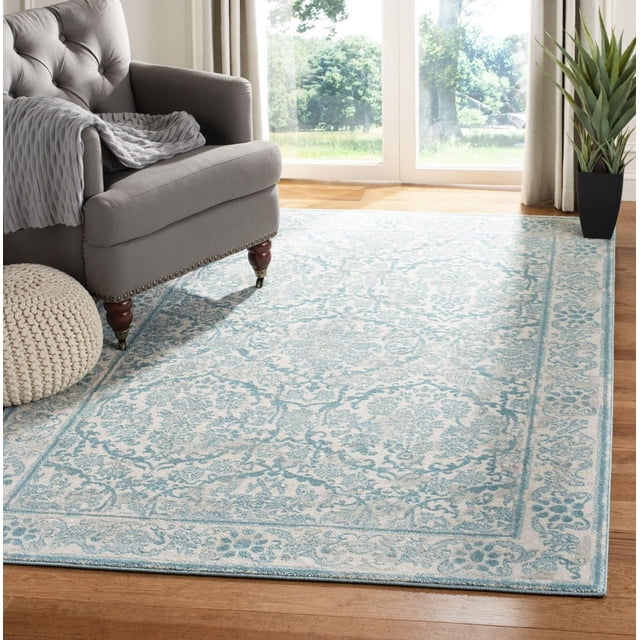 Safavieh Evoke Tapis Traditionnel Lorna en Bleu Doux et Crème avec Motif floral Détaillé et texture de Frise en Polypropylène Tissée Mécaniquement, Posé sur un Plancher de Bois Franc à Côté d'Un Fauteuil Capitonné Gris et d'Un pouf Tricoté Près de Portes en Verre Éclairées par le Soleil et d'Une Plante en Pot, Idéal pour une Déco de Salon durable et Stylée.