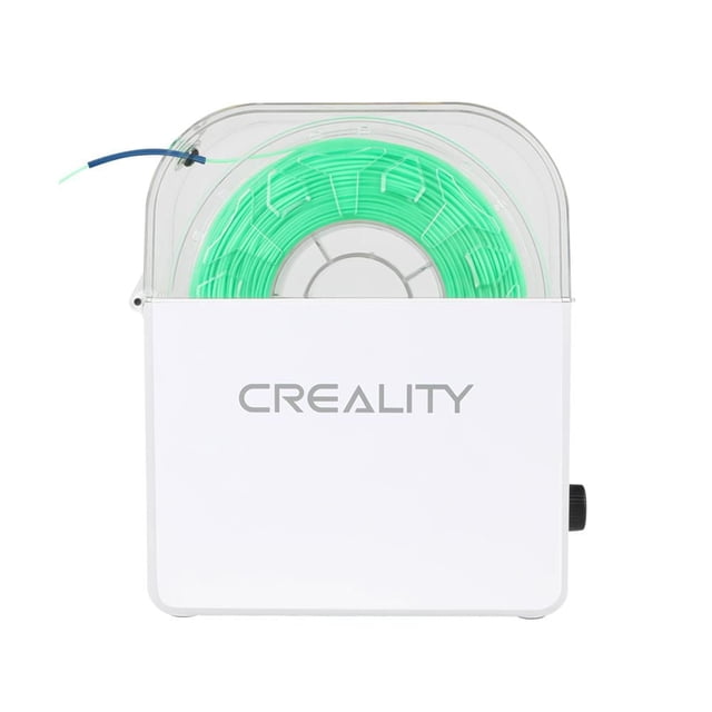 Creality Filament Dry Box with white plastic body and transparent top cover showing a spool of green 1.75mm 3D printer filament inside, featuring a side knob and screen for controlling drying time and temperature to keep filament dry and prevent print defects.