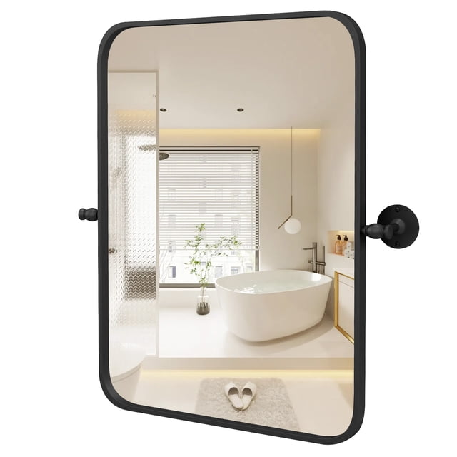 Costway 30 x 22 Inch Black Metal Framed Pivot Rectangle Wall-Mounted Mirror Black. This rectangular mirror features a matte black rustproof metal frame and a shatterproof silver glass surface for clear, distortion-free reflections. The pivot design allows for adjustable tilting, and it can be mounted horizontally or vertically. Shown in a modern bathroom setting with a freestanding bathtub and natural light.