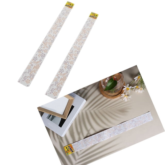SZXZYGS 10Pcs Home Fly Stick Hotel Bar Strip Paper Fly Ribbon (10ml) featuring two long, rectangular fly ribbons with a floral pattern. These sticky ribbons are designed for trapping flies and can be hung or placed on surfaces. One ribbon is displayed on a flat surface near a vase and books, suggesting potential decorative or crafting uses. Ideal for homes, restaurants, bars, and other hospitality settings.