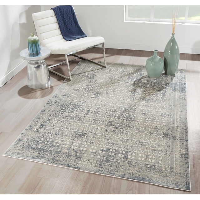 ECARPET Mabel Traditional Area Rug for Living Room, Bedroom, Dining Room, Entrance, Hallway and More with a vintage ornamental pattern in sage green and grey on durable synthetic fibers, displayed on light hardwood flooring with a white modern chair draped with a navy throw, a silver side table with a blue-green vase, and two green ceramic vases near a window, ideal for high-traffic home areas.