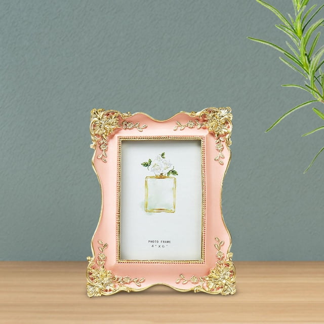 European Picture Frame Antique Picture Frames for Bedroom Desk Gallery in pink resin material with ornate gold floral accents. The rectangular table picture frame measures 22.5cm x 17cm and is displayed on a wooden tabletop against a muted green wall. Suitable for photos, artwork, or collages.