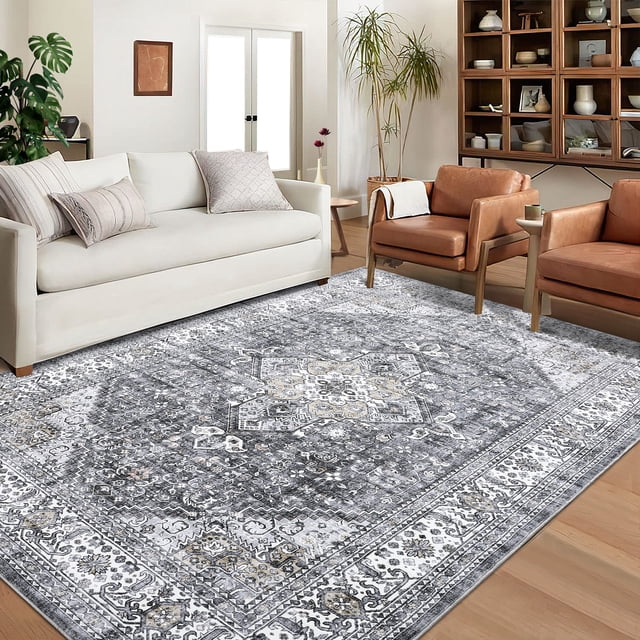FairOnly 8' x 10' area rug in grey with a modern abstract pattern, displayed in a living room setting. The rug features a thin, machine-washable construction with a durable TPR anti-slip backing, ensuring stability and safety for children, pets, and seniors. The intricate design adds a chic, decorative touch to the space, complementing the neutral-toned furniture and wooden flooring.