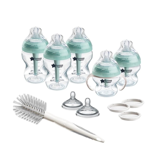 Tommee Tippee Natural Start Grow with Baby Bottle Set with six clear bottles in 5oz, 9oz, and 11oz sizes featuring green anti-colic vented nipples, one bottle with removable white handles, two extra medium-flow nipples, three white travel lids, and a white cleaning brush for easy self-sterilizing and colic reduction.