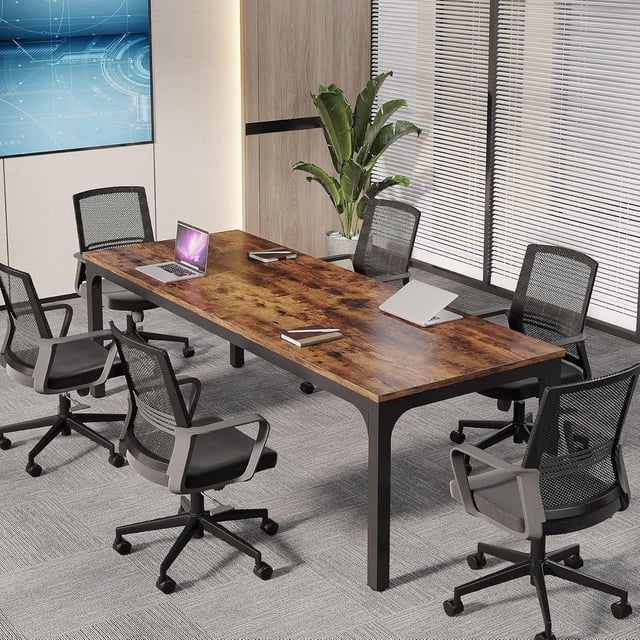 Tribesigns 13FT Large Conference Table in rustic brown finish, measuring 6.5FT x 2.3FT, designed for boardrooms and meeting spaces. Supported by a durable metal frame, the table seats 12-16 people and is shown in a modern office setting with mesh chairs on a grey carpet. Adjustable foot pads enhance stability and protect floors.
