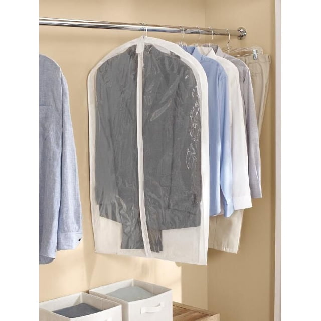 Mainstays Garment Bag, Hanging Clothing Zippered Garment Bag in white non-woven fabric with clear plastic front, hanging on a metal closet rod protecting a dark suit jacket, alongside dress shirts and pants in a beige closet, suitable for travel or seasonal storage.