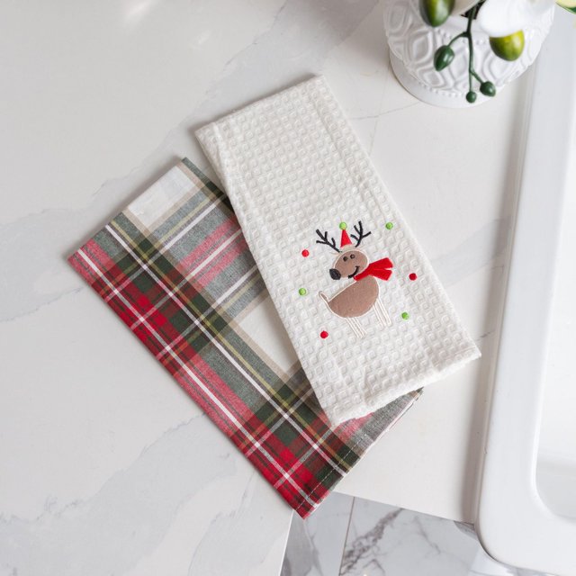 Ensemble de Serviettes de Cuisine en Coton 100 % à Carreaux Celebration avec Deux Lavettes 18 Pouces x 28 Pouces sur un Comptoir en Marbre Blanc; l'Un à Motif Carreaux Rouge, Vert et Blanc, l'Autre à Tissage Gaufré Blanc avec un Renne Brodé Portant une Foulard et un Chapeau Rouges, Idéal pour Sécher la Vaisselle et Essuyer les Déversements.