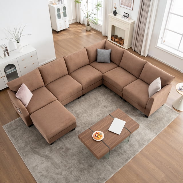 Noble House Canapé Sectionnel Modulaire en Forme de U avec Pouf de Rangement et Ports USB, Canapé d'Angle Surdimensionné 6 Places, Brun. Ce Sectionnel en Lin Présente un Spacieux design en Forme de U avec un Pouf de Rangement Caché et des Ports de Recharge USB et Type‐C Intégrés. le Tissu Brun Résistant au Boulochage et un Cadre Robuste en Bois et Métal Assurent Durabilité et Confort. Présenté dans un Salon Moderne avec un Tapis Gris Pâle, des Planchers en Bois et la Lumière Naturelle Provenant de Grandes Fenêtres.