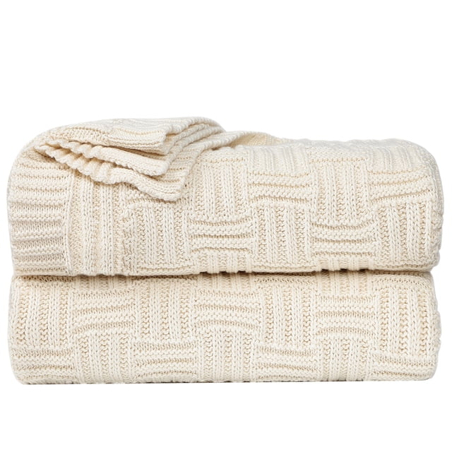 Unique Bargains 100% Cotton Cross Cable Knit Throw Blanket for sofa, couch, or bed in a beige colour. The blanket features a textured cross cable knit pattern and measures 47 x 70 inches (120 x 180 cm). Made from soft, breathable, and natural cotton, it is lightweight and suitable for various uses such as a travel blanket, sofa throw, or summer air conditioning blanket. The image shows the blanket neatly folded, highlighting its intricate knit design.