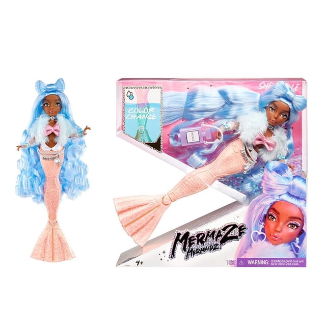Mermaze Mermaidz Changement de Couleur Shellnelle Poupée de Mode Sirène avec Accessoires Montrant une Poupée aux Longs Cheveux Bleu Ondulé Coiffée d'Un Grand Nœud, Portant un Haut à Nœud Rose Scintillant, Veste en Fausse Fourrure Bleue, et une Queue de Sirène Sculptée en Corail Qui Se Change en Bleu Sarcelle dans l'Eau Froide, Exposée à Côté de Son Emballage Rose et Blanc Mettant en Valeur la Fonction de Changement de Couleur et les Accessoires Inclus.