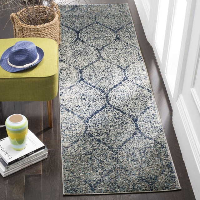 Safavieh Madison Leighton Tapis Géométrique Mettant en Vedette un Motif Géométrique Bleu et Gris sur un Fond Moucheté, Tissé Mécaniquement pour la Durabilité, Exposé dans un Couloir sur des Planchers de Bois Franc Sombres à Côté d'Un Banc Vert avec un Chapeau Bleu et des Livres, Idéal pour une Déco de Maison Moderne Transitionnelle et un Entretien Facile.