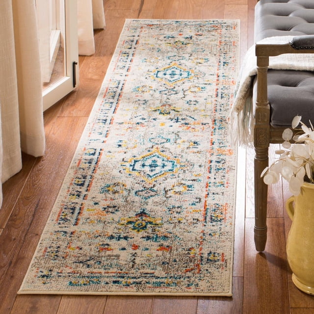 Safavieh Madison Alys Vintage Traditional Area Rug runner with a distressed multicolour pattern in blue, yellow, and orange on a beige background, power loomed for durability, placed on hardwood flooring beside a grey tufted bench and beige curtains, ideal for adding transitional style to hallways or entryways.