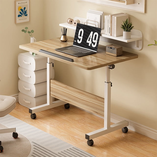 Petit Bureau Debout à Hauteur Réglable, Bureau Mobile Pliable avec Roulettes Petit Bureau d'Ordinateur Roulant Bureau de Bureau Réglable Assis-Debout Postes de Travail pour Petits Espaces et Bureaux à Domicile. le Bureau Présente un design Moderne et Minimaliste avec un Plateau en MDF et un Cadre en Tuyau d'Acier. le Bureau Mesure 80 x 40 cm et Sa Hauteur Est Réglable de 65 cm à 87 cm. Il Comprend des Roues Pivotantes à 360° Verrouillables pour la Portabilité et des Panneaux Pliables pour l'Efficacité de l'Espace. Présenté dans un Décor de Bureau à Domicile avec un Portable, des Livres et des Articles
