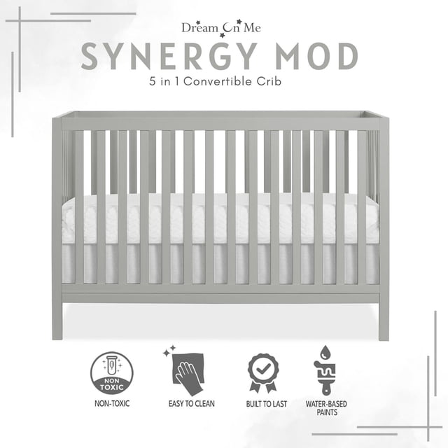 Dream On Me Synergy MOD Crib in cool grey finish, front-facing view showing wooden spindles and white mattress, crafted from sustainable New Zealand pinewood, designed as a 5-in-1 convertible baby crib for nursery furniture, featuring non-toxic, easy-to-clean, durable water-based paint.