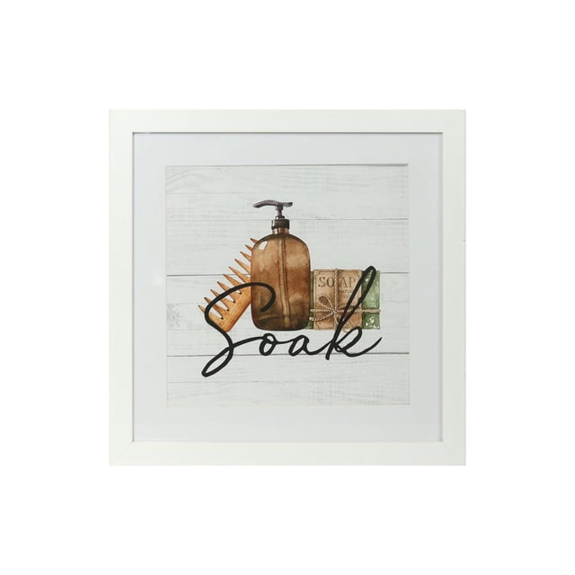 HOMETRENDS Framed Wall Art with a white frame and mat, displaying a watercolor illustration of a brown pump bottle, orange comb, and two soap bars on a whitewashed wood background with the word 'Soak' in black script, sized 12 by 12 inches, suitable as bathroom décor.